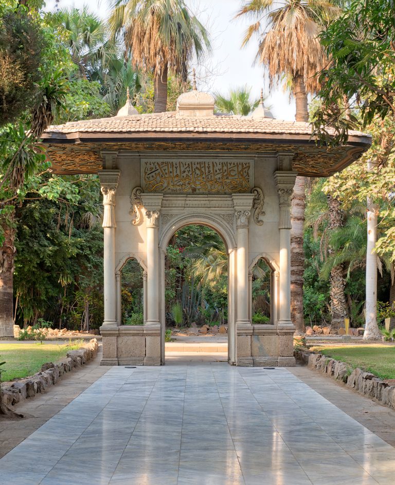 Porte-cochere (carriage porch, Gate) at the public park of Manial Palace of Prince Mohammed Ali Tewfik with marble tiled floor, trees and palms, Cairo, Egypt